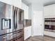 Contemporary kitchen with stainless steel refrigerator, granite countertops, and white cabinets at 7628 Surf Reed Way, Wesley Chapel, FL 33545