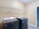 Laundry room with modern washer and dryer units and shelving at 7628 Surf Reed Way, Wesley Chapel, FL 33545
