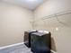 Convenient laundry room with shelving and modern washer and dryer units at 7628 Surf Reed Way, Wesley Chapel, FL 33545