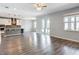 An open concept space featuring the kitchen, living and dining area with sliding glass doors and wood flooring at 7628 Surf Reed Way, Wesley Chapel, FL 33545