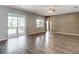 Open-concept living room with sliding glass doors to the lanai and wood-look flooring at 7628 Surf Reed Way, Wesley Chapel, FL 33545