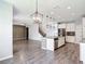 Open-concept living space with kitchen island and a view of the adjacent living area with staircase at 7628 Surf Reed Way, Wesley Chapel, FL 33545