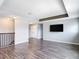 Open loft area with modern flooring, recessed lighting, and television hookups for a cozy entertainment space at 7628 Surf Reed Way, Wesley Chapel, FL 33545