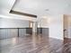 Spacious upstairs loft with dark wood railings and modern lighting fixtures, offering versatile living space at 7628 Surf Reed Way, Wesley Chapel, FL 33545