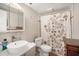 Well-lit bathroom featuring a vessel sink, floral shower curtain, and mirrored medicine cabinet at 801 Russell Ln # 252, Brandon, FL 33510