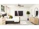 Bright bedroom featuring modern decor, neutral walls, and a large window with white curtains at 8064 Painted Sky Pl, Land O Lakes, FL 34637