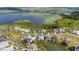 Aerial view of a neighborhood with lake views and lush landscaping, featuring single-Gathering homes at 8834 Sanders Tree Loop, Wesley Chapel, FL 33545