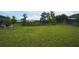 Expansive backyard with lush green lawn, mature trees, and a tranquil view of the lake at 8834 Sanders Tree Loop, Wesley Chapel, FL 33545