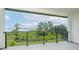 A balcony overlooking a backyard with natural landscapes and a lake in the distance at 8834 Sanders Tree Loop, Wesley Chapel, FL 33545