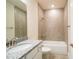 Bright bathroom featuring granite countertops, a large mirror and a shower over tub with tiled walls at 8834 Sanders Tree Loop, Wesley Chapel, FL 33545