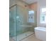 Bathroom shower with glass door, tiled walls and rainfall showerhead at 8834 Sanders Tree Loop, Wesley Chapel, FL 33545