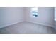 Bright, empty bedroom with neutral carpet, baseboards, and natural light from one window at 8834 Sanders Tree Loop, Wesley Chapel, FL 33545