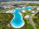 Aerial view of a large community lagoon with sandy beach and recreational amenities at 8834 Sanders Tree Loop, Wesley Chapel, FL 33545