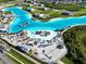 Aerial view of Epperson Lagoon with beach chairs and umbrellas on the white sand beach at 8834 Sanders Tree Loop, Wesley Chapel, FL 33545