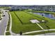 Large fenced community dog park with ample green space for pets, adjacent to a scenic pond at 8834 Sanders Tree Loop, Wesley Chapel, FL 33545