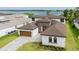 Stylish home with a well-manicured lawn, a paver driveway, and lake views at 8834 Sanders Tree Loop, Wesley Chapel, FL 33545