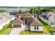 Elegant two-story home showcasing beautiful landscaping and a paver driveway leading to an attached two car garage at 8834 Sanders Tree Loop, Wesley Chapel, FL 33545