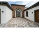 Inviting entrance to the home featuring a stone archway, double doors, and beautiful paving stones at 8834 Sanders Tree Loop, Wesley Chapel, FL 33545