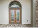 Close-up of elegant double front doors with decorative ironwork and an arched transom window at 8834 Sanders Tree Loop, Wesley Chapel, FL 33545