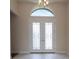Elegant white double doors with transom window and decorative ironwork, a grand entrance feature at 8834 Sanders Tree Loop, Wesley Chapel, FL 33545