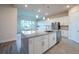 Kitchen island with granite countertops, stainless steel sink and appliances, and a view to the dining room at 8834 Sanders Tree Loop, Wesley Chapel, FL 33545