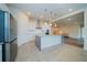 Modern kitchen with white cabinets, granite countertops, stainless steel appliances, and open view to living room at 8834 Sanders Tree Loop, Wesley Chapel, FL 33545