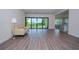 Open-concept living room featuring hardwood floors, sliding glass doors, and lots of natural light at 8834 Sanders Tree Loop, Wesley Chapel, FL 33545