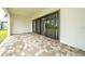 Spacious outdoor patio with large sliding glass doors and brick flooring, perfect for entertaining at 8834 Sanders Tree Loop, Wesley Chapel, FL 33545