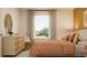 Comfortable bedroom with a dresser, chair, and large window offering natural light and scenic views at 9332 Cannon Beach Dr, Parrish, FL 34219