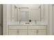 Elegant bathroom featuring a double vanity with marble countertop, sleek fixtures, and a well-lit shower at 9456 Gladsome Dr, Land O Lakes, FL 34637