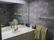 Bathroom with single sink vanity and decorative floral wallpaper at 9722 Indian Key Trl # 116, Seminole, FL 33776