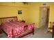 Bedroom with bright yellow walls and a red floral bedspread at 9722 Indian Key Trl # 116, Seminole, FL 33776