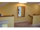 Inviting entryway featuring carpeted stairs, a mirror, and light yellow walls leading to a peek of the kitchen at 9722 Indian Key Trl # 116, Seminole, FL 33776