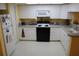 Bright kitchen featuring white cabinets, black appliances, and light countertops at 9722 Indian Key Trl # 116, Seminole, FL 33776