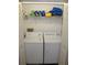 A washer and dryer sit beneath a storage shelf in this laundry room closet at 9722 Indian Key Trl # 116, Seminole, FL 33776