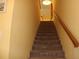 Carpeted staircase features a wooden handrail and leads to the upper level of the home at 9722 Indian Key Trl # 116, Seminole, FL 33776