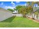 Expansive backyard with lush green grass, mature trees, and a white fence, offering privacy and plenty of room at 10513 Carrollview Dr, Tampa, FL 33618
