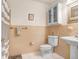 Vintage bathroom featuring pink tile accents, pedestal sink, and a classic medicine cabinet for storage at 10513 Carrollview Dr, Tampa, FL 33618