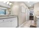 Neutral bathroom leads to the main bedroom, with white cabinetry, chrome fixtures, and stylish tile flooring at 10513 Carrollview Dr, Tampa, FL 33618