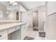Bright bathroom with double sinks, white cabinets, and tile flooring at 10513 Carrollview Dr, Tampa, FL 33618