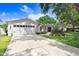 Well-maintained home with a two-car garage, a large driveway, and lush landscaping at 10513 Carrollview Dr, Tampa, FL 33618
