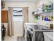 Well-organized laundry room with front loading washer and dryer, shelving, and a window for natural light at 10513 Carrollview Dr, Tampa, FL 33618