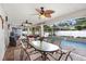 Screened outdoor dining area with a table and seating, leading to a pool with lush landscaping at 10513 Carrollview Dr, Tampa, FL 33618