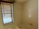 Cozy tub and shower combo bathroom with a small window and white tile at 10811 Candlin Ct, Riverview, FL 33578