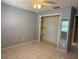 A neutral-toned bedroom with tile floors, a ceiling fan, a closet and a mirror at 10811 Candlin Ct, Riverview, FL 33578