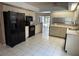 Open concept kitchen with black appliances, white cabinets, and tile floors at 10811 Candlin Ct, Riverview, FL 33578