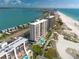 Breathtaking aerial shot of beachfront condos with a pool, situated along a beautiful coastline at 1270 Gulf Blvd # 1901, Clearwater Beach, FL 33767
