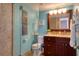 Stylish bathroom with a glass-enclosed shower, wood vanity, and turquoise walls at 1270 Gulf Blvd # 1901, Clearwater Beach, FL 33767
