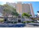 Elegant condo entrance showcasing a stone facade and lush landscaping with palm trees at 1270 Gulf Blvd # 1901, Clearwater Beach, FL 33767