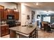Open kitchen featuring dark wood cabinetry, granite countertops, a kitchen island, and modern appliances at 12720 Hampton Hill Dr, Riverview, FL 33578
